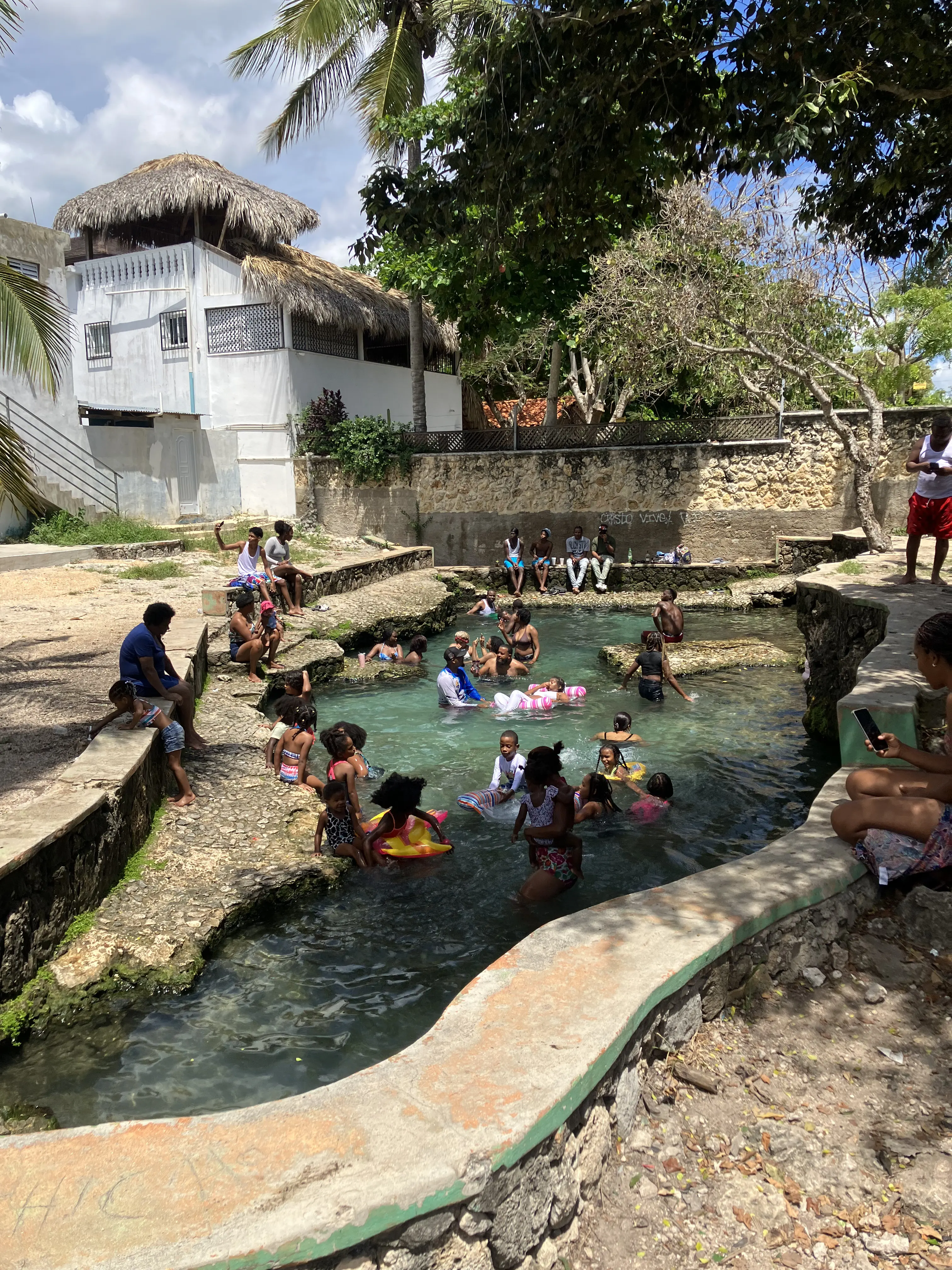 Kinder schwimmen im klaren Süßwasserbecken von Manantial La Batea in Bayahibe