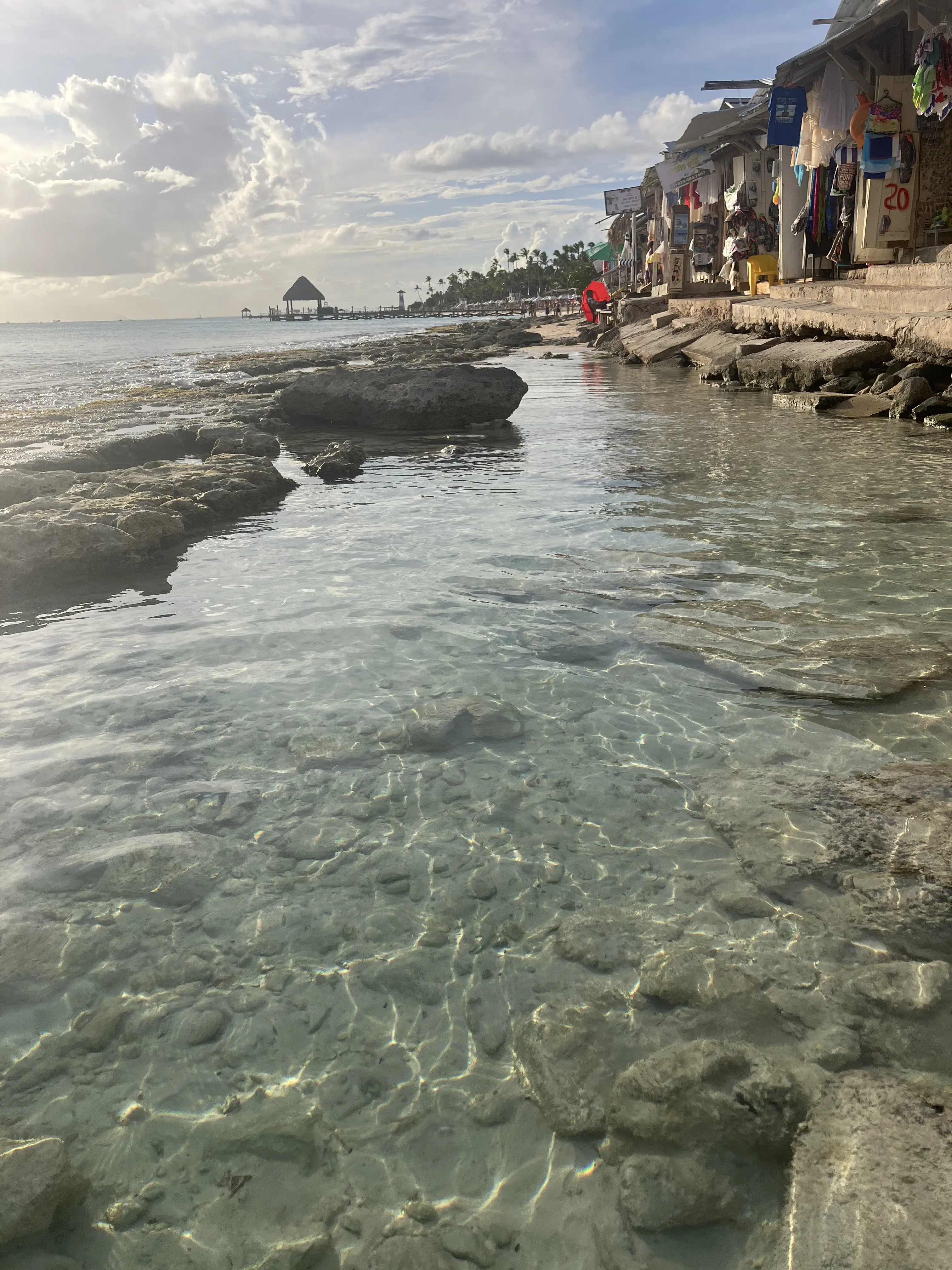 Kristallklares Wasser im natürlichen Becken mit den Souvenirläden rechts und dem Ozean links